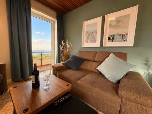 a living room with a couch and a table with a window at Haus Nige Wark - Ferienwohnungen in Cuxhaven