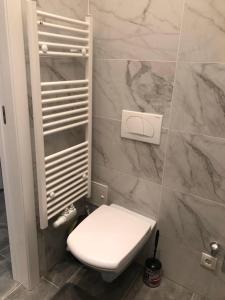 a bathroom with a white toilet and marble walls at Tayfun-Living in Vienna