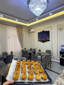 a tray of pastries on a table in a restaurant at ANNUR Boutique Hotel in Samarkand