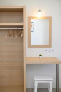 a dressing room with a mirror and a wooden closet at "Araklos" Summer houses in Aegiali