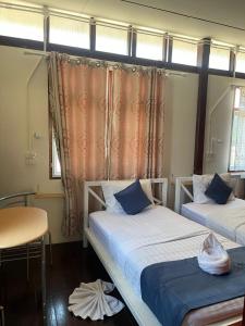 a room with two beds and a table and windows at Ladybugs hostel sunset in Taling Ngam Beach +6 photos
