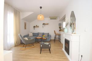 a living room with a blue couch and a fireplace at Apartments Katušić in Cavtat