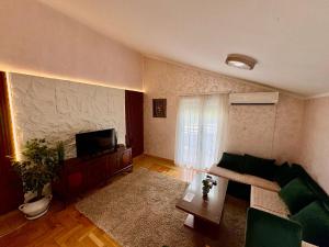 a living room with a couch and a tv at Blue Escape in Danilovgrad