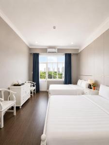 a hotel room with two beds and a window at CCT Luxury Hotel in Nha Trang +78 photos