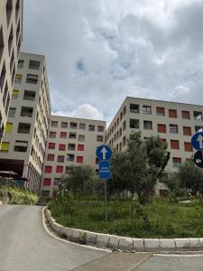a street sign in front of two tall buildings at 13 Daily apartments in Tirana