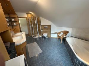a bathroom with a tub and a sink and a toilet at Fewo Susi Allgäu in Buchloe +26 photos