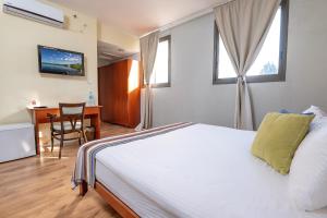 a bedroom with a bed and a desk with a computer at Villa Nazareth - Boutique hotel in a central location in Nazareth