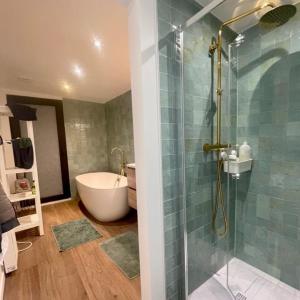 a bathroom with a shower and a tub and a sink at Deep Forest in Bastogne +33 photos