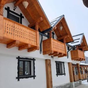 a house with wooden balconies on the side of it at Domeniul Ursului in Vadu Izei