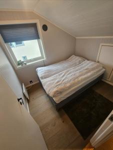a small bedroom with a bed and a window at Sentral og moderne base i Lofoten in Vestvågøya +4 photos