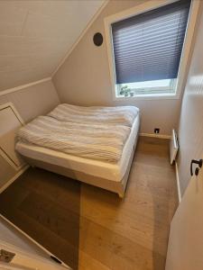 a bed in a small room with a window at Sentral og moderne base i Lofoten in Vestvågøya
