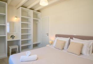 a bedroom with a large white bed with white pillows at "Araklos" Summer houses in Aegiali +70 photos