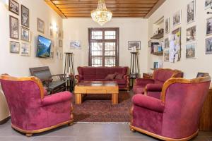 a living room with red chairs and a table at Villa Nazareth - Boutique hotel in a central location in Nazareth