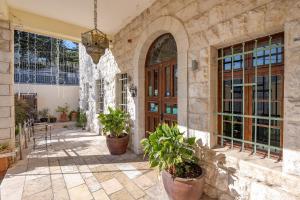 a stone building with potted plants in a courtyard at Villa Nazareth - Boutique hotel in a central location in Nazareth