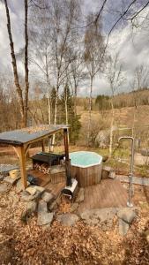 a hot tub on a wooden deck with a picnic table at Deep Forest in Bastogne