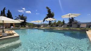 a swimming pool with chairs and umbrellas at La Casetta Agriturismo in Santa Sofia