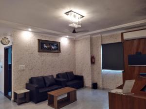 a living room with a couch and a flat screen tv at Hotel Sahajtam Inn in Sonīpat