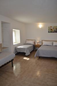 ein Zimmer mit drei Betten, einem Tisch und einem Fenster in der Unterkunft Al Canto in Rota d'Imagna