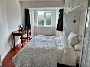 a bedroom with a bed and a desk and a window at 19 Westlands in Westport