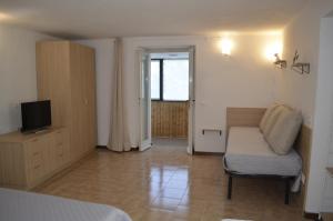 ein Schlafzimmer mit Bett, Fernseher und Sofa in der Unterkunft Al Canto in Rota d'Imagna