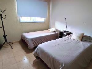 a room with two beds and a window at Casa Nuup in Río Tercero
