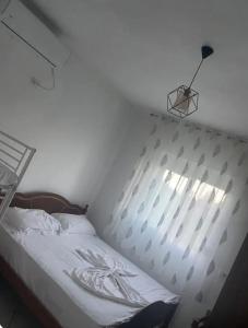 a bedroom with a white bed with a metal headboard at Guesthouse Oasis in Baks-Rrjoll