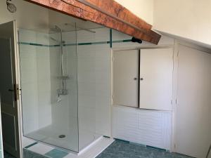 a shower with a glass door in a bathroom at Maison en pierre cosy chez Laëtitia in Auros +7 photos