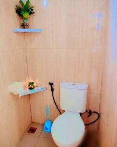 a bathroom with a white toilet in a room at Bunaken Paradise Beach Homestay in Bunaken +57 photos