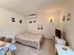 a small room with a bed and a television at Villa Gromaca in Omišalj