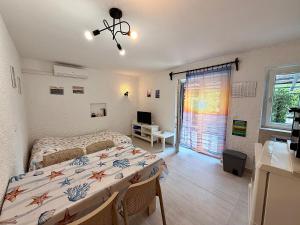 a bedroom with two beds and a television in it at Villa Gromaca in Omišalj