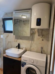a bathroom with a washing machine and a mirror at Stone Throne Retreat in Drušići +15 photos