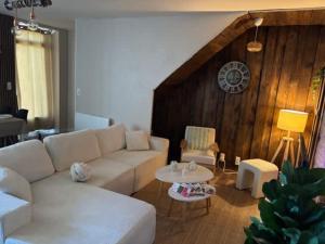 a living room with a white couch and a table at L'escapade du temps in Les Épesses