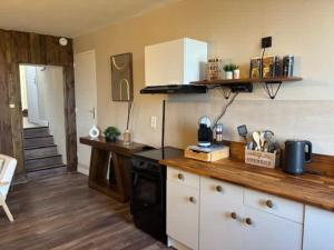 a kitchen with a wooden counter top and a stove at L'escapade du temps in Les Épesses