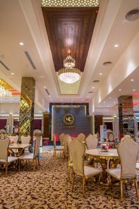 a dining room with tables and chairs and a chandelier at Fun Square Hotel in Sangrūr +10 photos
