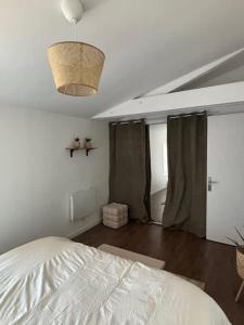 a bedroom with a white bed and a ceiling at L'escapade du temps in Les Épesses +4 photos