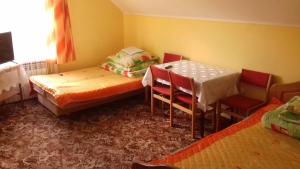 a room with two beds and a table and chairs at Noclegi Renata in Solina
