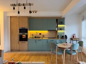 a kitchen with blue cabinets and a table with chairs at Mare e Monti in Bar