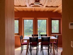 a dining room with a table and chairs and windows at Ethno holistic village Apače - Nature Retreat in Slovenia in Apače