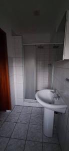 a bathroom with a white sink and a shower at HL Self-catering Accommodation in Bonnievale