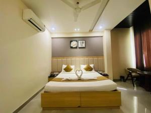 a bedroom with a large bed with a wooden frame at Fun Square Hotel in Sangrūr