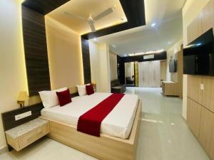 a bedroom with a large bed with a red blanket at Fun Square Hotel in Sangrūr