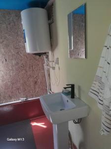 a bathroom with a white sink and a mirror at Gasthaus Jasur,Yakkakhona in Madovra +4 photos