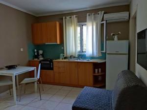 una cucina con un frigorifero bianco, un tavolo e un lavandino di Morfi a Città di Lefkada