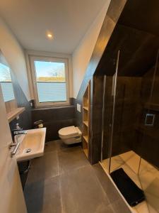 a bathroom with a sink and a toilet and a shower at Gaststätte Bongsiel 'Dat Swarte Peerd' in Ockholm +18 photos