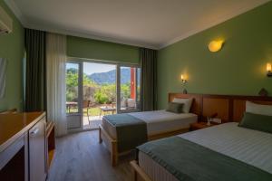 a hotel room with two beds and a large window at Odile Hotel by Naturelife in Cıralı +133 photos