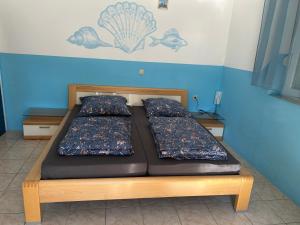 a bed with two pillows on it in a room at Apartments Lilly Weiss in Banjol