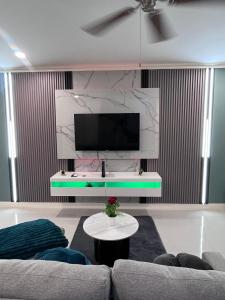 a living room with a couch and a tv on a wall at Palistic Paradise luxury private jacuzzi in Portmore