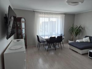 a kitchen and living room with a table and a couch at Melnragė in Melnragė
