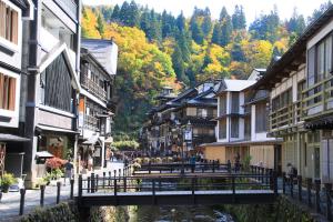 a bridge over a river in a town with buildings at 甘口派Stay in Tsurumakida