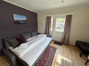 a bedroom with a bed and a couch and a window at Hofslund Apartments in Sogndal